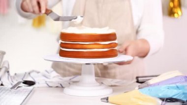 Adım adım. Pasta Şef yığın pasta katmanları arasında tek boynuzlu at pasta oluşturmak için buzlanma buttercream ile
