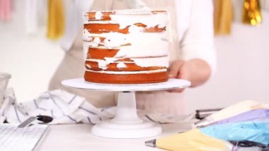 Adım adım. Pasta Şef yığın pasta katmanları arasında tek boynuzlu at pasta oluşturmak için buzlanma buttercream ile