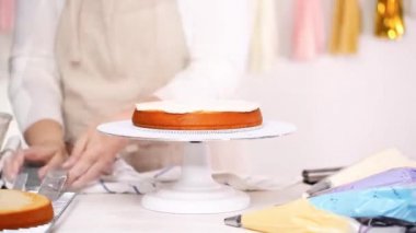 Zaman atlamalı. Adım adım. Pasta Şef yığın pasta katmanları arasında tek boynuzlu at pasta oluşturmak için buzlanma buttercream ile