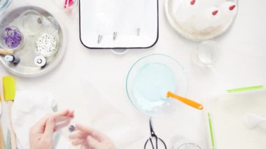 Üstten görünüm. Adım adım. Gıda tek boynuzlu at şekerli kurabiye süslemek için Royal Icing içine boyama karıştırma.