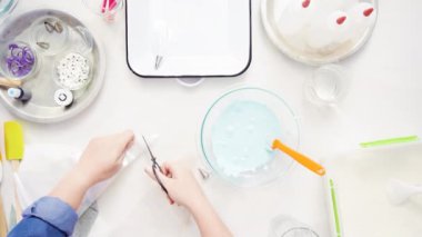 Üstten görünüm. Adım adım. Gıda tek boynuzlu at şekerli kurabiye süslemek için Royal Icing içine boyama karıştırma.