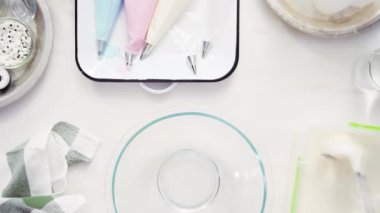 Üstten görünüm. Adım adım. Gıda tek boynuzlu at şekerli kurabiye süslemek için Royal Icing içine boyama karıştırma.