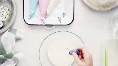 Üstten görünüm. Adım adım. Gıda tek boynuzlu at şekerli kurabiye süslemek için Royal Icing içine boyama karıştırma.