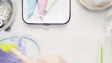 Üstten görünüm. Adım adım. Gıda tek boynuzlu at şekerli kurabiye süslemek için Royal Icing içine boyama karıştırma.