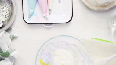 Üstten görünüm. Adım adım. Gıda tek boynuzlu at şekerli kurabiye süslemek için Royal Icing içine boyama karıştırma.