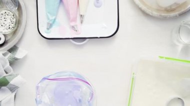 Üstten görünüm. Adım adım. Gıda tek boynuzlu at şekerli kurabiye süslemek için Royal Icing içine boyama karıştırma.