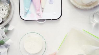 Üstten görünüm. Adım adım. Gıda tek boynuzlu at şekerli kurabiye süslemek için Royal Icing içine boyama karıştırma.
