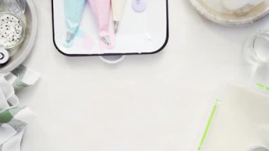 Üstten görünüm. Adım adım. Gıda tek boynuzlu at şekerli kurabiye süslemek için Royal Icing içine boyama karıştırma.