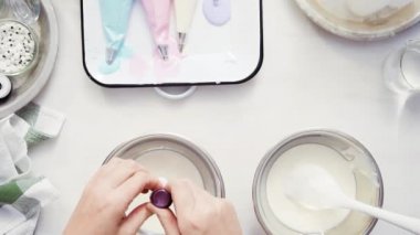 Üstten görünüm. Adım adım. Gıda tek boynuzlu at şekerli kurabiye süslemek için Royal Icing içine boyama karıştırma.