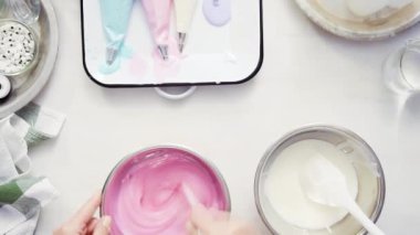 Üstten görünüm. Adım adım. Gıda tek boynuzlu at şekerli kurabiye süslemek için Royal Icing içine boyama karıştırma.