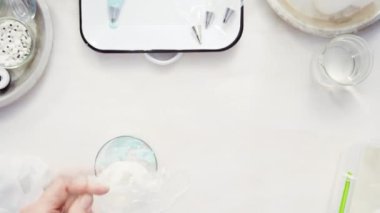 Zaman atlamalı. Üstten görünüm. Adım adım. Gıda tek boynuzlu at şekerli kurabiye süslemek için Royal Icing içine boyama karıştırma.