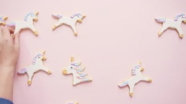 Tek boynuzlu at şekerli kurabiye pembe bir arka plan üzerine Kraliyet krema ile dekore edilmiş