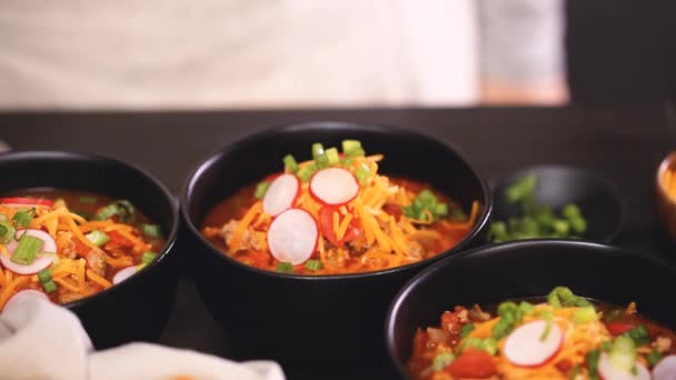 Close Turkey Chili Garnished Fresh Radishes Green Onions Cheddar Cheese — Stock Video