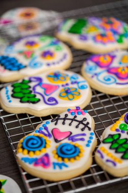 Şekerli kurabiye şeker kafatası şeklinde renkli Kraliyet buzlanma ile dekore edilmiştir.