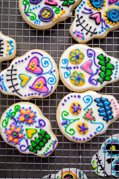 Sugar cookies in shape of sugar skull decorated with colorful royal icing