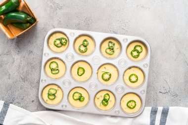 Mısır ekmeği kek baharatlı jalapeno biber gri arka plan üzerinde muffin tavada meyilli