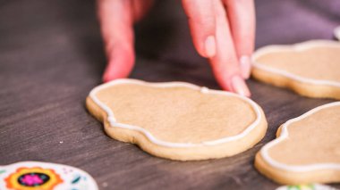 şeker kafatası kurabiye ahşap arka plan üzerine Kraliyet krema ile sel için kenar oluşturma