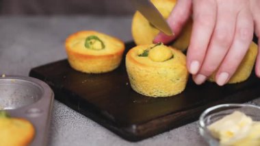 Kadın şef kesme Mısır ekmeği ve jalapeno muffins masada Close-up