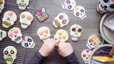 Adım adım. Düz yatıyordu. Farklı renk royal Icing ile şeker kafatası çerezleri dekorasyon