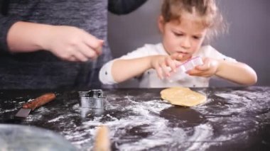 Anne ve kızı kesme şeker kafatası hamur ürünleri Dia de los Muertos tatil için.