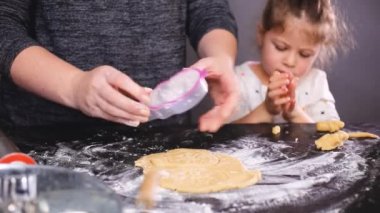 Anne ve kızı kesme şeker kafatası hamur ürünleri Dia de los Muertos tatil için.