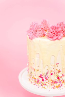 Pembe ve beyaz buttercream krem kek pembe sprinkles ve beyaz çikolata ganache damla.
