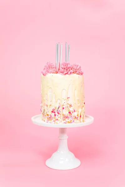 ピンク振りかけるとホワイト チョコレートのガナッシュ点滴クリーム ピンクと白のバター クリーム ケーキの上 の誕生日の蝋燭 — ストック写真