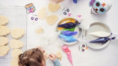 Anne ve kızı şeker kafatası kurabiye Dia de los Muertos tatil için Kraliyet buzlanma ile dekorasyon üstten görünüm.