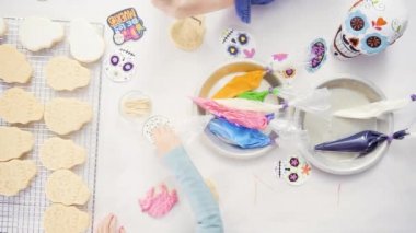 Anne ve kızı şeker kafatası kurabiye Dia de los Muertos tatil için Kraliyet buzlanma ile dekorasyon üstten görünüm.