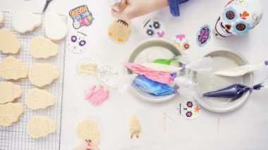 Anne ve kızı şeker kafatası kurabiye Dia de los Muertos tatil için Kraliyet buzlanma ile dekorasyon üstten görünüm.