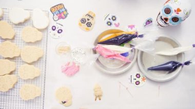 Anne ve kızı şeker kafatası kurabiye Dia de los Muertos tatil için Kraliyet buzlanma ile dekorasyon üstten görünüm.