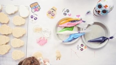 Anne ve kızı şeker kafatası kurabiye Dia de los Muertos tatil için Kraliyet buzlanma ile dekorasyon üstten görünüm.