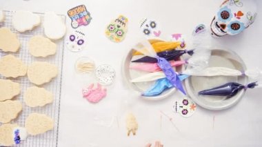 Anne ve kızı şeker kafatası kurabiye Dia de los Muertos tatil için Kraliyet buzlanma ile dekorasyon üstten görünüm.