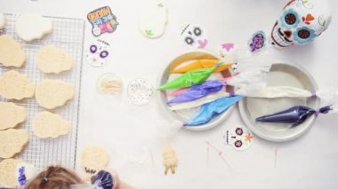 Anne ve kızı şeker kafatası kurabiye Dia de los Muertos tatil için Kraliyet buzlanma ile dekorasyon üstten görünüm.