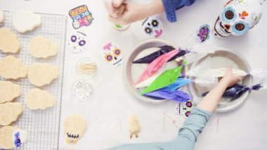 Anne ve kızı şeker kafatası kurabiye Dia de los Muertos tatil için Kraliyet buzlanma ile dekorasyon üstten görünüm.