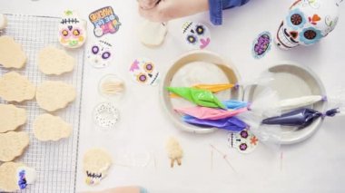 Anne ve kızı şeker kafatası kurabiye Dia de los Muertos tatil için Kraliyet buzlanma ile dekorasyon üstten görünüm.