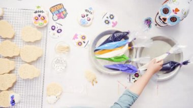 Anne ve kızı şeker kafatası kurabiye Dia de los Muertos tatil için Kraliyet buzlanma ile dekorasyon üstten görünüm.