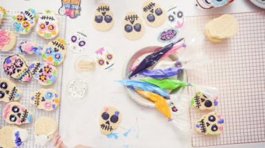Anne ve kızı dekorasyon Dia de los Muertos tatil için Kraliyet buzlanma ile kafatası tanımlama şeker.