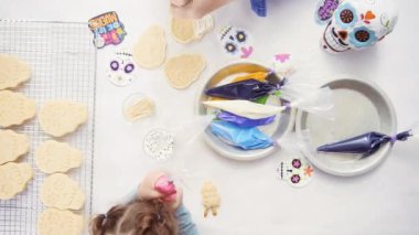 Anne ve kızı dekorasyon Dia de los Muertos tatil için Kraliyet buzlanma ile kafatası tanımlama şeker.