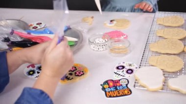 Anne ve kızı şeker kafatası kurabiye Dia de los Muertos tatil için Kraliyet buzlanma ile dekorasyon kırpılmış görünümünü.