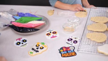 Anne ve kızı şeker kafatası kurabiye Dia de los Muertos tatil için Kraliyet buzlanma ile dekorasyon Close-up.