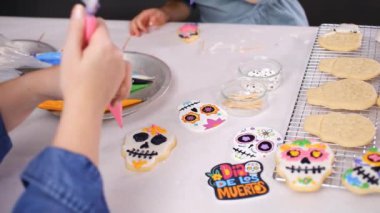 Anne ve kızı şeker kafatası kurabiye Dia de los Muertos tatil için Kraliyet buzlanma ile dekorasyon Close-up.