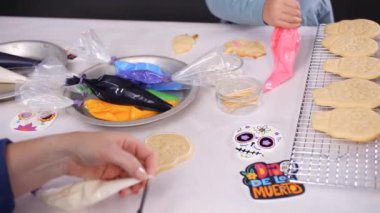 Anne ve kızı şeker kafatası kurabiye Dia de los Muertos tatil için Kraliyet buzlanma ile dekorasyon Close-up.