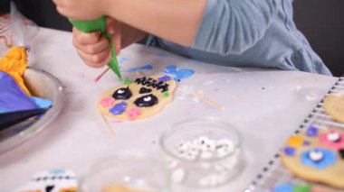 Dia de los Muertos tatil için Kraliyet buzlanma ile şeker kafatası çerezleri dekorasyon küçük kız görünümünü kırpılmış.