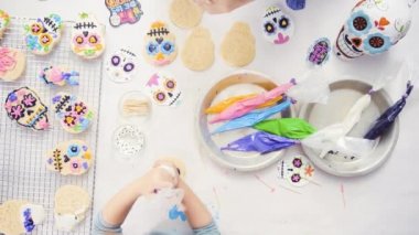 Anne ve kızı şeker kafatası kurabiye Dia de los Muertos tatil için Kraliyet buzlanma ile dekorasyon havai görünümü.