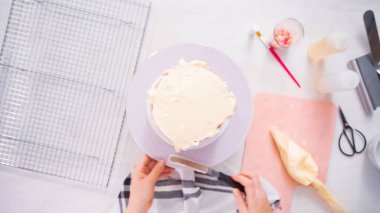 Adım adım. Düz yatıyordu. Uzun boylu Doğum günü pastası beyaz buttercream buzlanma ile krema.