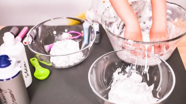 Adım adım. Anne ve kızı renkli kabarık slime yapmak.