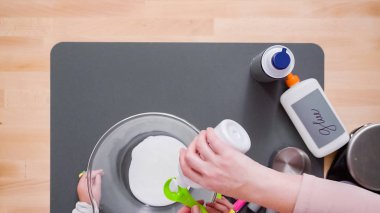 Adım adım. Anne ve kızı renkli kabarık slime yapmak.
