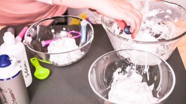 Adım adım. Anne ve kızı renkli kabarık slime yapmak.