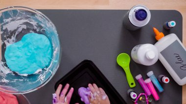 Adım adım. Anne ve kızı renkli kabarık slime yapmak.